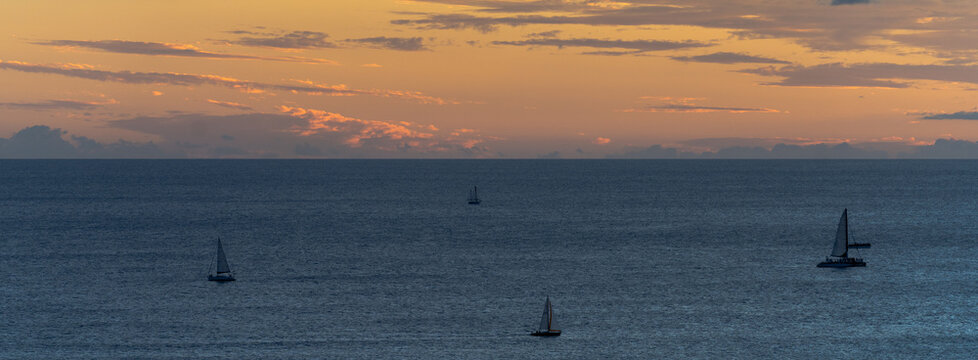 Sailboats Silhouetted on Pacific Ocean at Sunset in Hawaii
