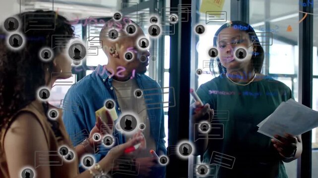 Right colleague pointing at glass wall and starting animated user icons while team aligning design