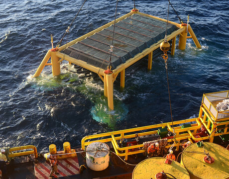 A subsea module is lowered from a barge into Bass Strait during offshore construction.