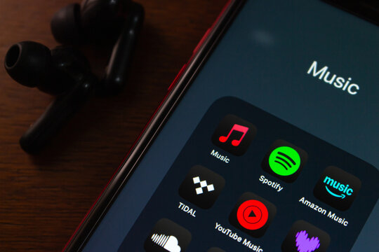 Quito, ECUADOR - Oct 6 2025 : Close-up of a smartphone screen showing popular music streaming apps include Music, Spotify, Amazon Music, Tidal, YouTube Music, Soundcloud, Deezer, in dark mode style, b