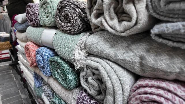 Blankets displayed in a busy market area during the day