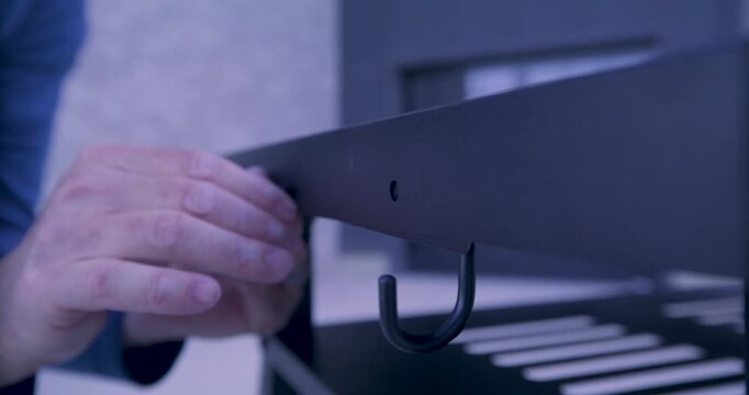 Man's shaky hands attempting to screw bolt onto metal platform - closeup