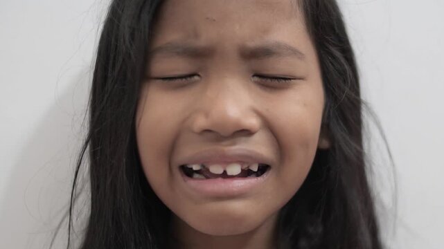 Upset little Asian girl crying with tears on face, sad child feeling disappointed and hurt, childhood bullying, loneliness, and emotional trauma