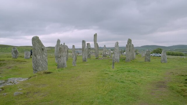 Wide shot of tourists inspecting the Callanish stone circle on Lewis.