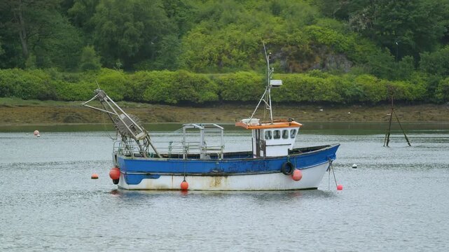 Static shot of a small, creel fishing boat anchored in Stornoway harbour.