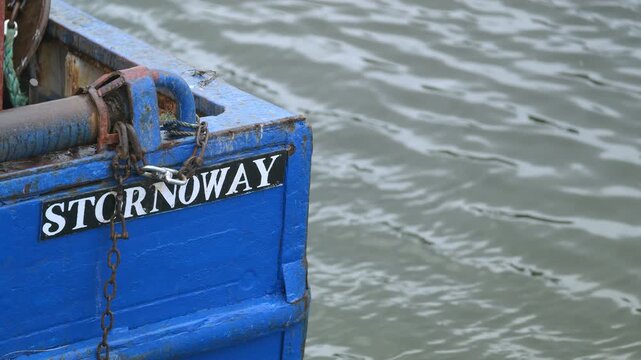 Static shot of the stern of a fishing boat moored at Stornoway harbour.