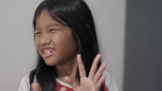 Hysterical little Asian girl crying and looking terrified, panicked child with fearful expression and defensive hand gesture, childhood trauma, bullying, and domestic fear