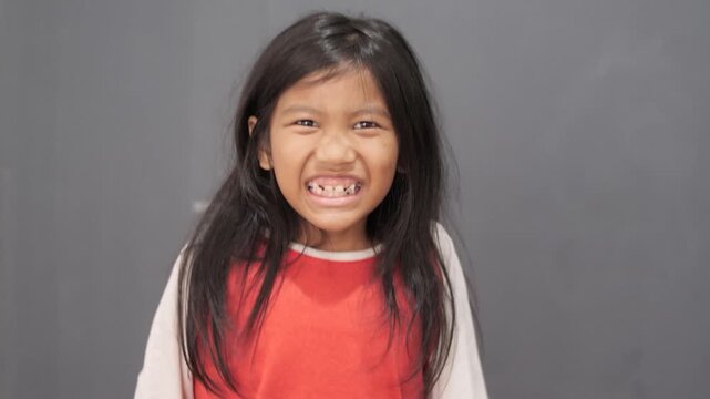 Little Asian girl shouting loudly and screaming with angry expression, child tantrum, frustrated and disappointed childhood