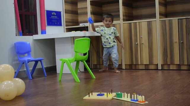 Child playing with colorful shape sorter toy, learning to match shapes and improve motor skills, coordination and problem solving in a bright home setting. Early education fun activity for kids growth