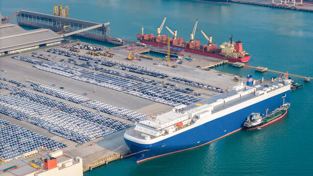 massive car carrier and cargo ships docked at a commercial port terminal. Global automotive trade logistics, container freight transport, and commodity supply chain concept.