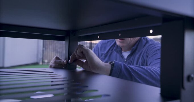 Man hand screwing screw into metal structure -closeup