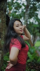 Naklejka premium Portrait of a Young Asian Woman in a Red Top Posing Outdoors