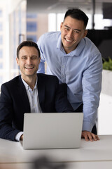 Team portrait two smiling multiethnic businesspeople ceo mentor and coworker trainee enjoying...