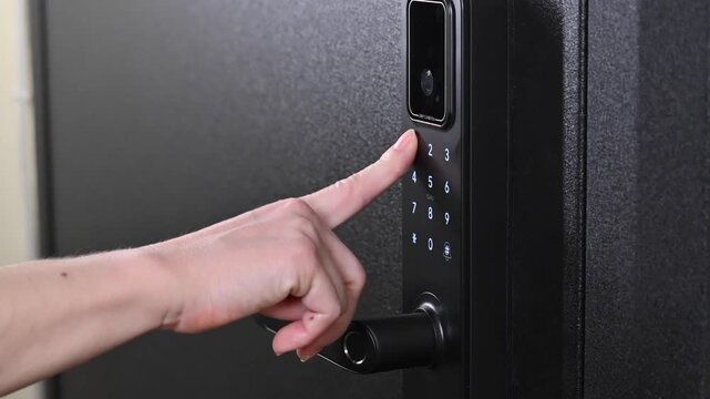 A woman opens a modern smart door lock with a digital keypad using a code.