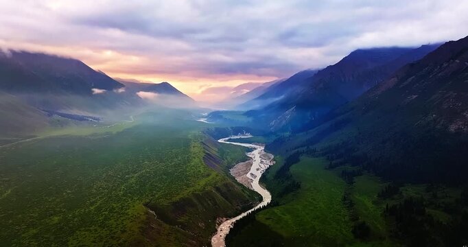 Aerial view of a scenic meandering river in a mountain valley at sunset, Xinjiang, China.