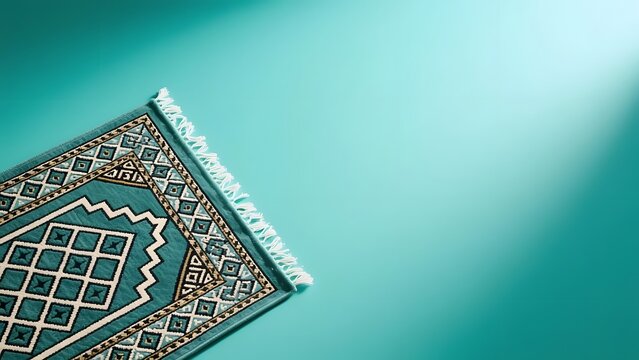 Islamic prayer rug on turquoise background, traditional muslim prayer mat with geometric patterns, religious worship concept with copy space