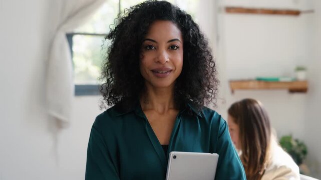 Video of fashion designer holding digital tablet while posing and looking at camera in a coworking place