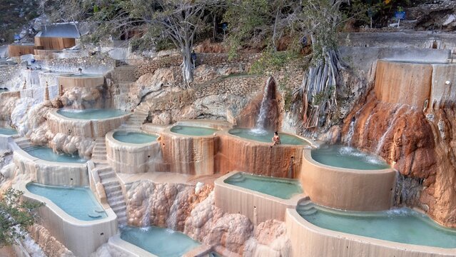 Cascading mineral pools glow turquoise beneath warm earth tones