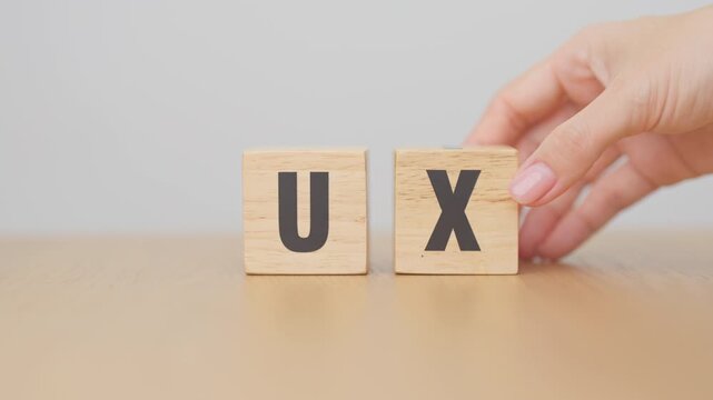 hand change wooden block from UI to UX. User Interface and User Experience, Usability, Information Architecture, IA, Research, Prototype, Testing, Onboarding, Design Thinking and Wireframe concepts