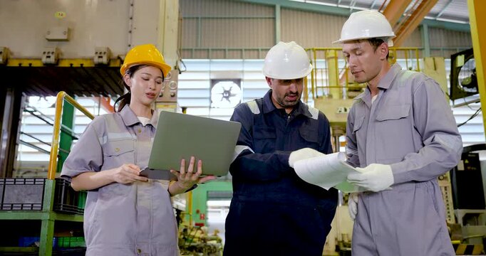 Asian adult female technician presents laptop in slow motion while supervisor and engineer review report nearby, combining digital monitoring, inspection discussion, teamwork workflow control.
