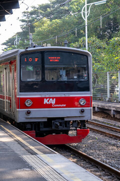 Jakarta, Indonesia - March 17, 2026: Close-up of a KAI Commuter train stopped at Palmerah Station, showing the front carriage beside the platform and railway tracks in daylight