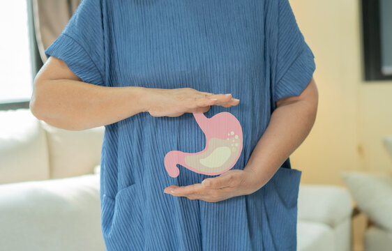 Senior woman with stomach feeling pain or gastric while standing