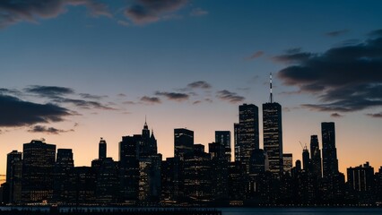Fototapeta premium New York City skyline silhouettes against a twilight sky with dramatic clouds, reflecting urban grandeur.