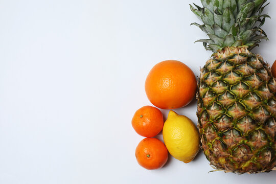 Citrus fruits and pineapple on table with space for text
