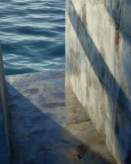 Fototapeta premium Abstract architectural details of a pier structure with water, creating contrasts in texture and form