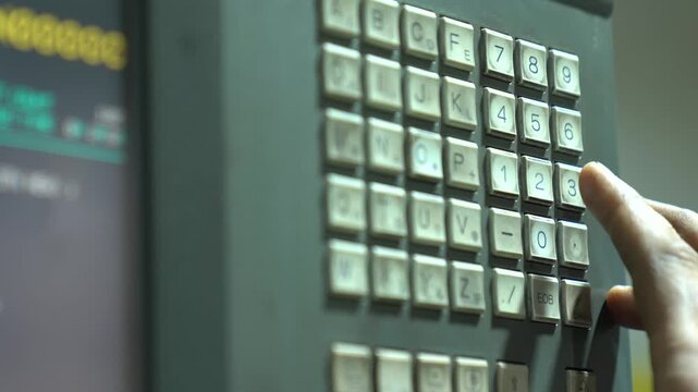 Close Up Shot Of A Machinist Pushing Buttons While Programming A CNC Machine Computer In A Workshop.
