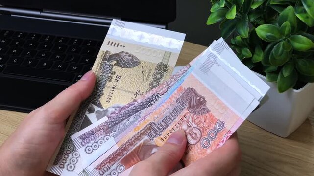 A girl sorts and counts Cambodian riel banknotes of various denominations. Concept of budgeting, financial accounting, and expense control.