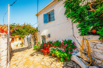 Fototapeta premium Alley decorated with flowers in the picturesque village of Afionas vacation on the island of Corfu in Greece near Porto Timoni beach