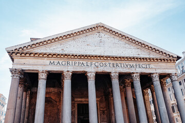 Naklejka premium Pantheon stands tall in Rome with strong columns and ancient design under blue sky