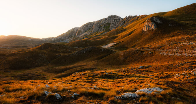 Grand panoramic view from Prutas peak at sunset, overlooking the dramatic limestone ridges and deep valleys of Durmitor National Park, Montenegro.