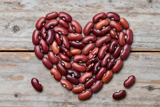 red beans in the shape of a heart on a wooden table