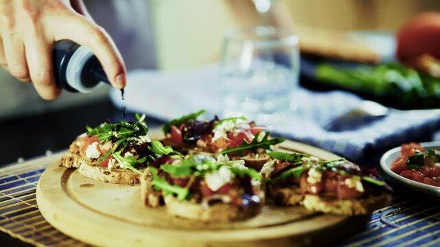 Drizzling Balsamic Sauce On Fresh Bruschetta With Tomatoes And Arugula. Mediterranean Appetizer