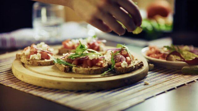 Chef Hands Garnishing Italian Bruschetta With Fresh Arugula. Preparing Mediterranean Appetizer