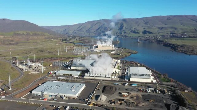 4K Aerial drone footage of a large data center campus with cooling steam, electrical substation along the Columbia River in The Dalles, Oregon, USA. Power demand for cloud computing AI infrastructure