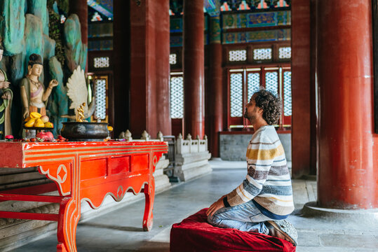 Man kneeling in Beijing temple praying for spirituality