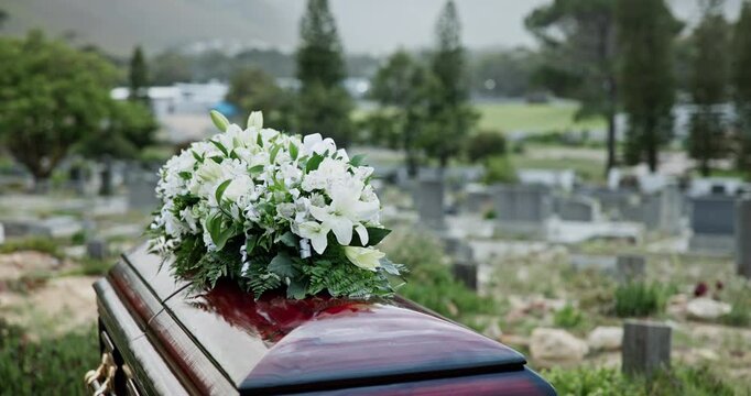 Funeral, coffin and graveyard with flowers in nature for death, passing or outdoor memorial service. Empty, casket and wooden box with protection in cemetery for tradition or culture at burial site