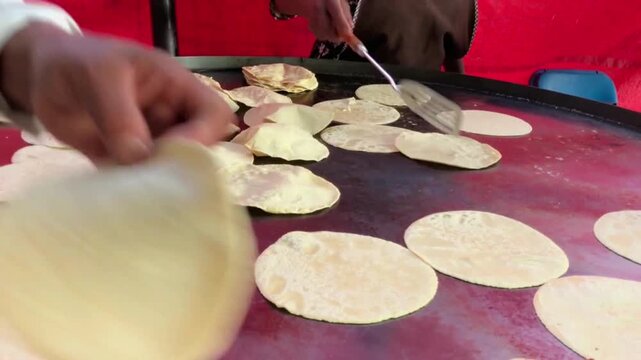 Sensory and tactile footage of fingers squishing and manipulating soft white dough for culinary preparation.