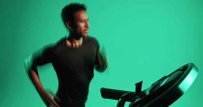 Treadmill, running and man in studio for fitness, training and fast runner with action. Cardio machine, speed and person exercise for health, motion blur and sprint for wellness on green background