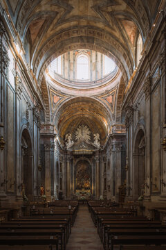 Interior of the 18th-century Basilica da Estrela in Lisbon, Portugal, showing the ornate Baroque nave, vaulted ceiling, and illuminated altar beneath the central dome.