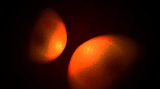 A bright orange flame glows like a solar star against the dark night, creating a hot energy pattern and colorful texture as the burning match fire shines in the deep black space