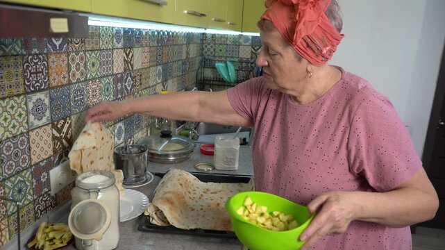 Pita roll with apples. Woman cooking food at home. Make pies.