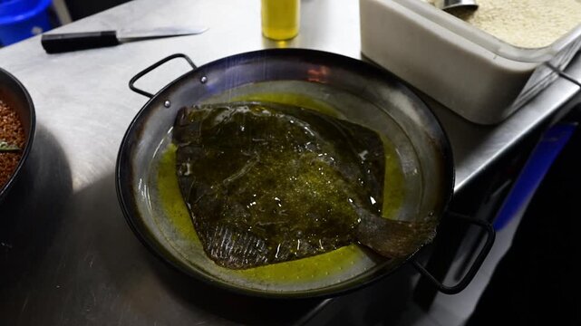 Chef putting a baked turbot flatfish into the oven
