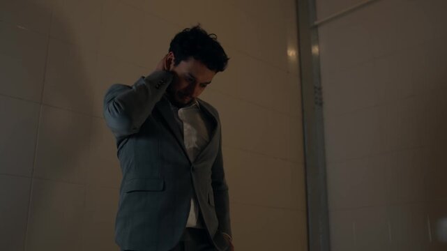 Man in cell, reflecting deeply in a small, somber, confined space