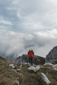 Hiker on a rocky mountain ridge in the clouds