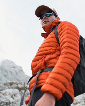 Hiker in an orange jacket on a mountain summit