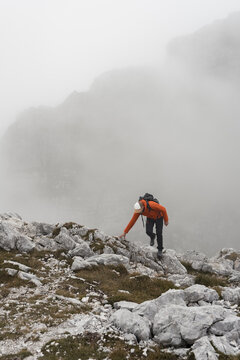 Hiker stands on a peak against a vast mountain landscape